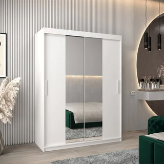 A modern bedroom with the CHOICEWARDROBE Tavira 2 Door Sliding Mirrored Wardrobe (150 cm, white), central mirrored panels reflecting a green bed, plus a round vanity with hanging lights and neutral decor.