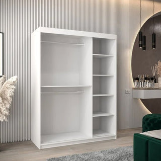 The CHOICEWARDROBE Tavira 2 Door Sliding Wardrobe (150cm, Matt White) offers modern bedroom storage with shelves and drawers, ideal for rooms with light wood flooring and decorative accents.