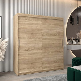 The CHOICEWARDROBE Tavira 2 Door Sliding Wardrobe (180 cm, Sonoma Oak finish) with modern shelves and hanging space stands by a grooved wall, beside a round mirror, hanging lights, green armchair, and pampas grass.