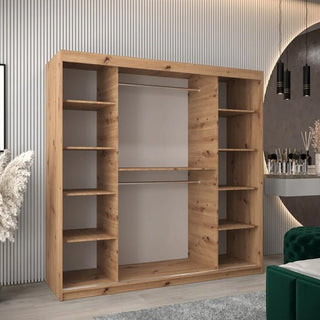 A CHOICEWARDROBE Tavira 2 Door Sliding Wardrobe (200cm, Artisan Oak finish) with shelves, drawers, and hanging rails stands against a grooved wall beside a vanity area with round mirror, plants, and pendant lights.