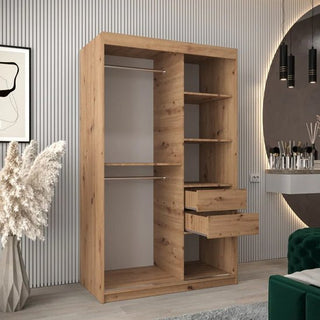 The CHOICEWARDROBE Tavira 2 Door Sliding Wardrobe in natural oak features shelves and drawer storage, standing in a modern room with vertical wall panels, pampas grass decor, and a round mirror.