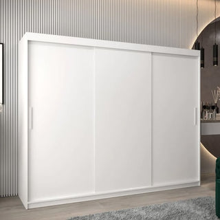 A CHOICEWARDROBE Tavira 250cm 3 Door Sliding Wardrobe in white with shelves and hanging rails stands against a textured wall with vertical lines. Modern decor includes a partial vanity and round mirror on the right.
