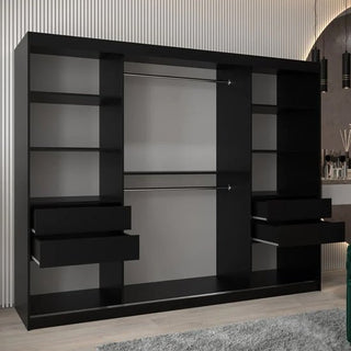 The CHOICEWARDROBE Tavira 3 Door Mirrored Sliding Wardrobe in black features full mirror panels, a modern design, optional LED lighting, and a spacious interior with shelves and drawers. It stands against a paneled wall on a light floor near decorative accents.