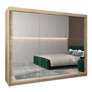 The CHOICEWARDROBE Tavira 3 Door Sliding Mirrored Wardrobe in an oak finish offers a 250cm extra-wide design with full-length mirrors, smooth sliding doors, and premium storage space for a modern bedroom.