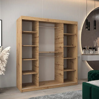 The CHOICEWARDROBE Tavira Wardrobe 180cm in artisan oak finish, with 2 sliding doors, spacious shelving, and hanging storage stands against the paneled wall. A round mirror, pampas grass, and pendant lights complete the bedroom décor.