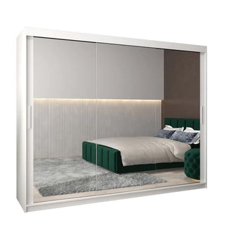 The CHOICEWARDROBE Tavira White High Gloss Mirrored Sliding Wardrobe (250cm, 3 doors) adds luxury bedroom storage with shelves, drawers, and hanging rails, perfectly complementing a green bed, gray rug, beige bedding, and lit vertical paneling.