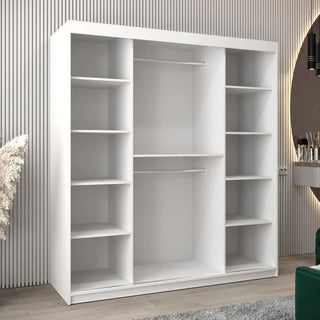 The CHOICEWARDROBE Tavira White Mirrored Sliding Wardrobe (180cm, 2 doors) with shelves, drawers, and a hanging rail stands in a room with light wood flooring and vertical stripe wallpaper. A round mirror and decorative plant are partly visible.