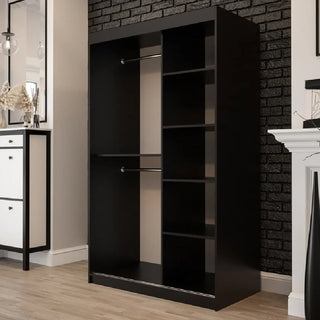 The CHOICEWARDROBE Topeka 120cm Dark Oak & Black Sliding Wardrobe features 2 mirror doors, two hanging rods on the left, and four vertical shelves on the right—perfect for modern industrial bedrooms with light wood floors and a dark brick accent wall.