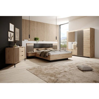 Modern bedroom with a wooden bed, two nightstands, dresser, and the CHOICEWARDROBE Turin Artisan Oak Sliding Door Wardrobe with Mirror & LED Lighting. Light wood floors, beige rug, wall art, vertical wood paneling, and a large window complete the look.