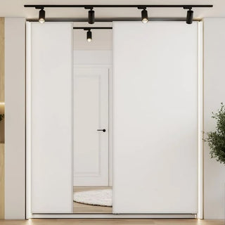 The CHOICEWARDROBE Vesso 3 Door Mirrored Sliding Wardrobe (Matt White, 235cm) features sleek mirrored sliding doors, ceiling-mounted LED lighting, and a modern look with black track lights above. A white door with black handle and a round rug are visible inside.