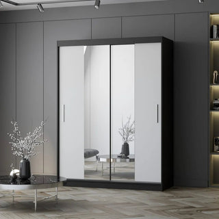 The CHOICEWARDROBE Vetra 2 Door Sliding Mirror Wardrobe (150cm, Matt White with Black Trim) stands by built-in shelves, while a round table with a decorative vase brings style to the modern bedroom storage area.