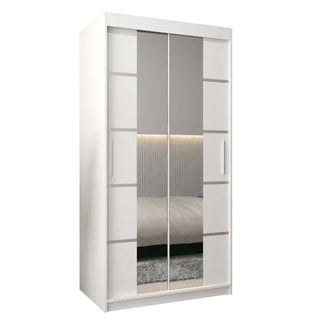 The CHOICEWARDROBE Vevey 100cm White Mirrored Sliding Door Wardrobe features a modern panel design and a full-length mirror that reflects a bed with headboard, striped wall panel, and part of the carpet.