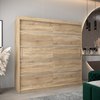 The CHOICEWARDROBE Vevey 200cm 2 Door Oak Sliding Wardrobe with a contemporary wood grain design stands against a grooved wall, paired on the right with a vanity, round mirror, and pendant lights for cozy style; pampas grass decor completes the look.