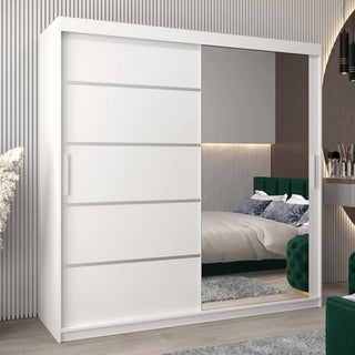 The CHOICEWARDROBE Vevey II 200cm Mirrored Sliding Door Wardrobe in a white finish, with shelves and hanging rails, stands in a modern bedroom; the mirrors reflect a bed, green upholstered furniture, and a vanity table.