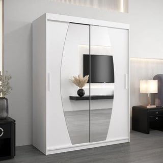 The Eden Mirrored Wardrobe 2 Sliding Doors 150cm in Artisan Oak stands in a modern bedroom, reflecting a mounted TV, floating shelf with a vase of dried grass, and part of a bedside table with a lamp.