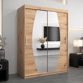 The Eden Mirrored Wardrobe with 2 sliding doors (150cm, White) stands against a light wall. Its silver handles reflect a black TV and a vase with dried plants in the mirrored doors.