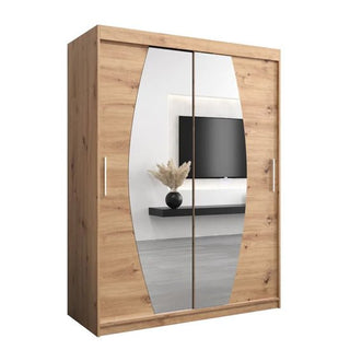 The Eden Mirrored Wardrobe 2 Sliding Doors 150cm in White features large vertical oval mirrors, reflecting a wall-mounted TV and a vase with dried grass on a black shelf—an elegant addition to any bedroom.