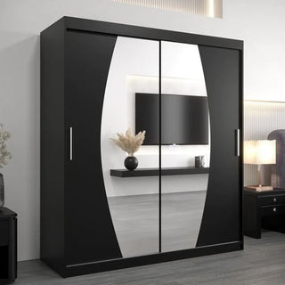 The Eden Mirrored Wardrobe 2 Sliding Doors 180cm in Black reflects a wall-mounted TV, floating shelf with vase, and bed in a modern bedroom—a stylish, sleek addition to your bedroom furniture collection.