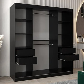 The Eden Mirrored Wardrobe 2 Sliding Doors 180cm in Black, featuring sleek modern design, is styled as bedroom furniture and placed in a room with light wood flooring and a striped wall.