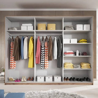 The Gitega Wooden Wardrobe 2 Sliding Doors 270cm in Matt White features two rails for hanging clothes, shelves for boxes, bags, and folded items, shoes organized at the bottom, and a light rug placed in front.