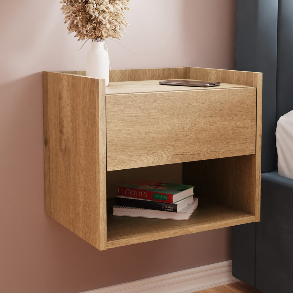Hever wall-hung oak bedside cabinet with drawer and open shelf, displaying books and a vase.