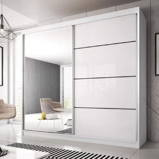 The Mesa 183cm Mirrored Wardrobe with 2 sliding doors in white gloss stands in a bright, minimalist room with a beige chair, striped rug, large windows, and a gray accent wall.