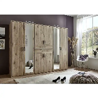 Oak mirrored wardrobe with six doors and full-length mirrors styled in a modern UK bedroom, reflecting light for a bright and balanced look.