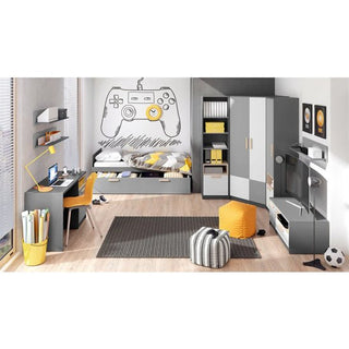 A modern bedroom features gray and yellow furniture, a bed, a desk with computer, shelves, rug, TV unit, and the Pearl Kids Wooden Wardrobe With 2 Doors In Graphite. A large game controller design decorates the wall above the bed.