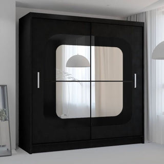 The COVINA 2 Door Mirrored Sliding Wardrobe in black (150cm) stands stylishly in a modern, bright room with white curtains and a hanging light, offering contemporary bedroom storage.