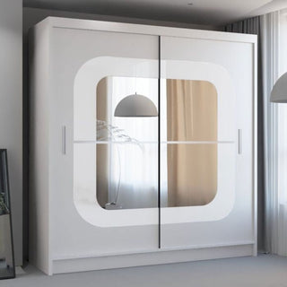 The COVINA 2 Door Mirrored Wardrobe in white (150cm) features a large central mirror and sliding doors, providing practical bedroom storage while standing on a light floor near a window with sheer curtains.