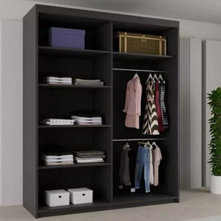 The CHOICEWARDROBE Heffner 2 Door Sliding Wardrobe (180cm, black) features shelves with folded clothes, boxes, and two bags. The right side has hanging garments like shirts, dresses, and pants. A green plant sits beside the wardrobe.
