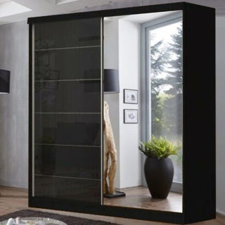 The INFINITE 2 Door Mirrored Wardrobe in black (150cm) features high gloss sliding doors—one mirrored, one opaque. Perfect for bedroom storage, it complements spaces with large windows, plants, sculptures, and wall art.