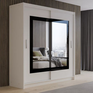 White 2-door sliding wardrobe with black framed mirror, reflecting bedroom interior and city view.