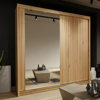 The ZEUS 2 Door Mirrored Wardrobe Oak 150cm features a sturdy sliding design with vertical wooden slats on one side and a full-length mirror on the other, complementing the modern room’s minimal decor and geometric coffee table.