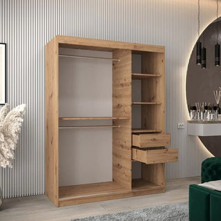 The Tavira I Mirrored Wardrobe with 2 sliding doors in artisan oak (150cm) stands in a modern room with a ribbed wall, decorative items, and a green velvet chair nearby.