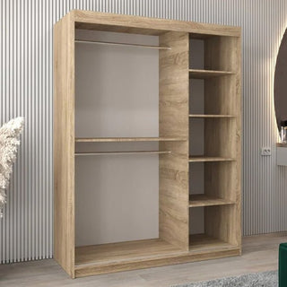 The Tavira I Mirrored Wardrobe with 2 sliding doors (150cm, Sonoma Oak) features an open design, two left hanging rods, five right shelves, and stands against a vertically grooved wall in a modern room.