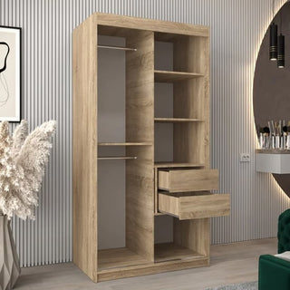 The Tavira II Mirrored Wardrobe with 2 sliding doors in Sonoma Oak, featuring open compartments, two hanging rods, and two drawers, stands in a modern room with striped walls, decorative plants, and a vanity in the background.