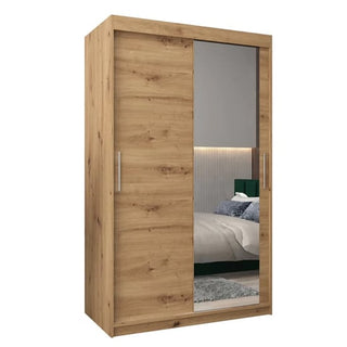 The Tavira II Mirrored Wardrobe features two 120cm sliding doors—one with a full-length mirror and one in Artisan Oak—set against a white background for an elegant touch.