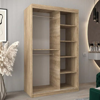 A Tavira II Mirrored Wardrobe with 2 sliding doors in Sonoma Oak stands in a modern room, showcasing two hanging rods and five shelves. It's placed beside vertical wall panels, a round mirror, and stylish décor.