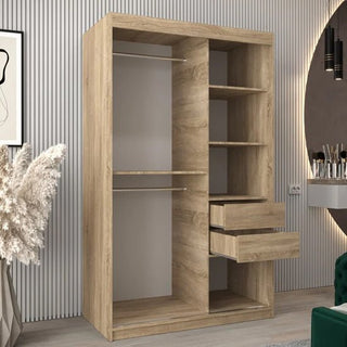The Tavira II Mirrored Wardrobe with 2 sliding doors in Sonoma Oak, featuring two hanging rods, three open shelves, and two open drawers, stands against a striped wall in a modern room with decor and a vanity.
