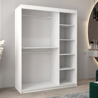 The Tavira II Mirrored Wardrobe 2 Sliding Doors 150cm in White features two hanging rods on the left and four open shelves on the right, set in a modern room with a striped wall, green chair, and round vanity mirror nearby.