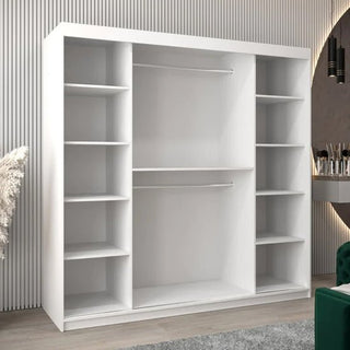 The Tavira II Mirrored Wardrobe with 2 sliding doors (200cm, white) features multiple side shelves and two central hanging rods, placed in a modern room with light walls and a gray floor.