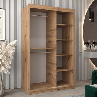 The Tavira III Mirrored Wardrobe with 2 sliding doors (120cm) in Artisan Oak features two left-side hanging rods and right-side shelves, shown in a modern room with decorative accents and vertical wall panels.