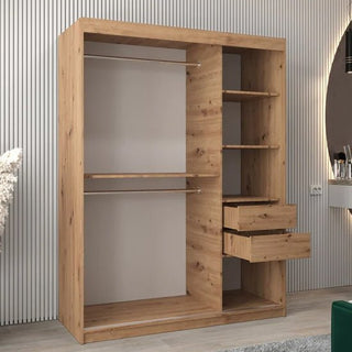 The Tavira III Mirrored Wardrobe in artisan oak features two sliding doors, a mirrored front, hanging rods, shelves, and drawers, all in a sleek 150cm-wide design against a light vertically-striped wall.