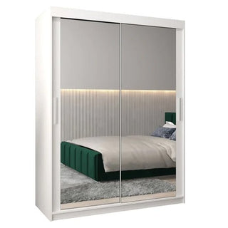 The Tavira III Mirrored Wardrobe with 2 sliding doors (150cm, white) reflects a modern bedroom with a green upholstered bed, gray rug, and horizontal light strip wall paneling.