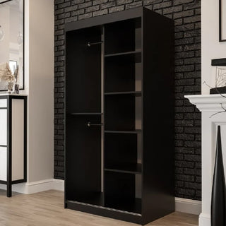 The Topeka Wooden Wardrobe With 2 Sliding Doors in Dark Oak offers stylish bedroom storage with open compartments, shelves, and two hanging rods, set against a black brick wall in a modern room with light wood flooring.