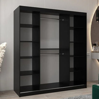 The Vevey I Wooden Wardrobe in black, featuring two sliding doors, central hanging rods, and side shelves, stands against a light-colored vertically-striped wall.