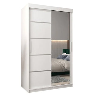 The Vevey II Mirrored Wardrobe 2 Sliding Doors 120cm in White features one solid and one mirrored sliding door, reflecting a stylish bedroom scene with a bed and wall decor against a simple background.