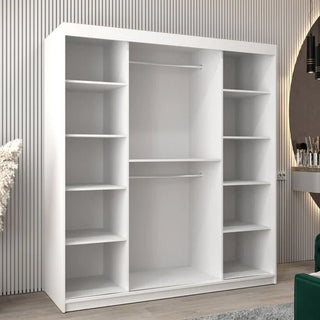 The Vevey II Mirrored Wardrobe with 2 sliding doors in white (180cm) stands against a vertically grooved wall. A round mirror and vanity table to the right complete this stylish, modern mirrored wardrobe setup.