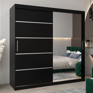 The Vevey II Mirrored Wardrobe (200cm, 2 sliding doors) in black, with horizontal silver lines and a large mirror, stands in a modern bedroom reflecting a bed and green upholstered furniture.
